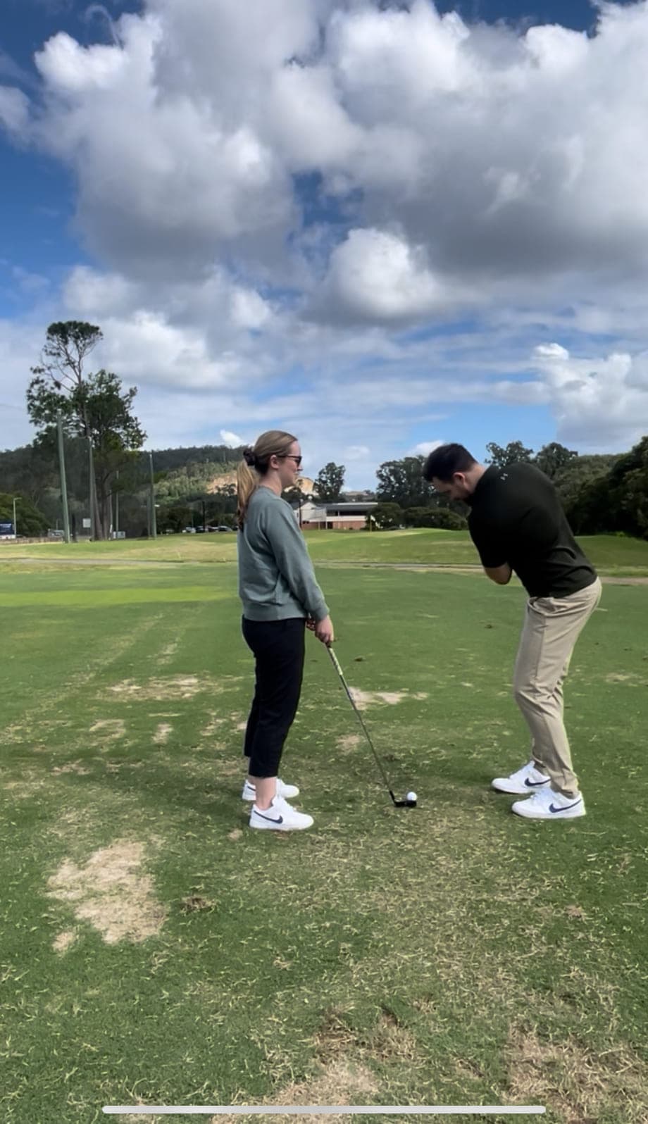Cameron Radburn observing a golfer’s set-up position on the fairway during a golf movement assessment.